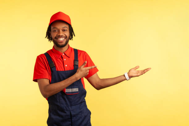 istock Worker presenting copy space on palm, pointing aside, advertisement of housekeeping service. 1343292413