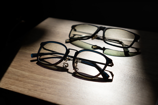Couple of Eyeglasses on Table with Shadow