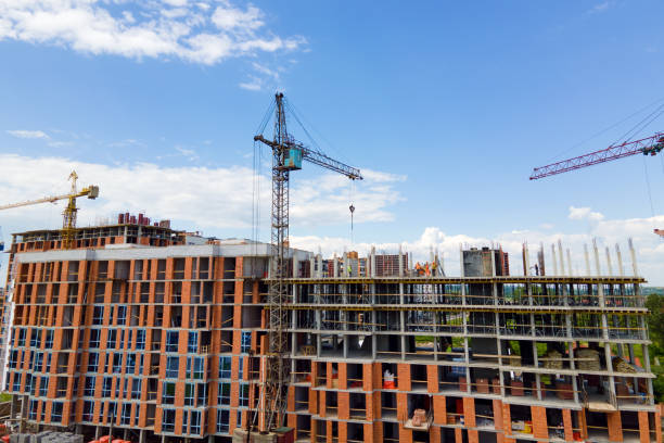 istock Tower crane at high concrete residential building under construction. Real estate development concept. 1343297002