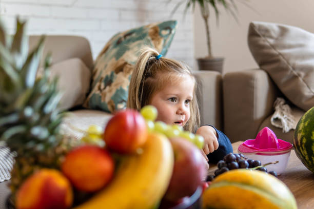 istock Cute girl with fresh fruit at table 1343298302