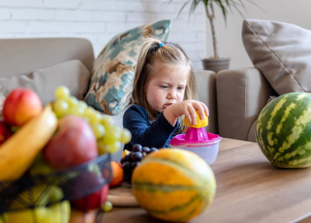 istock Little girl making fresh fruit juice 1343298342