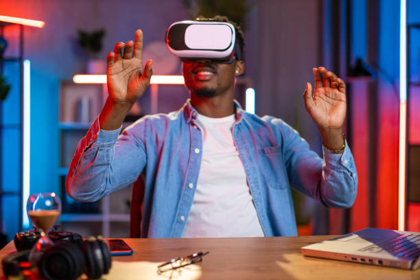 istock African man using VR glasses and laptop for remote work 1343298343