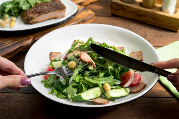 istock Salad in a white plate, spices and cutlery 1343298698