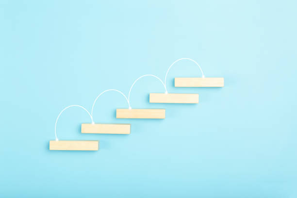 istock Business growth, development plan concept and business analytics background. Wooden steps of blocks on a blue background as financial and career growth, increase in monetary income and economic development. 1343299448