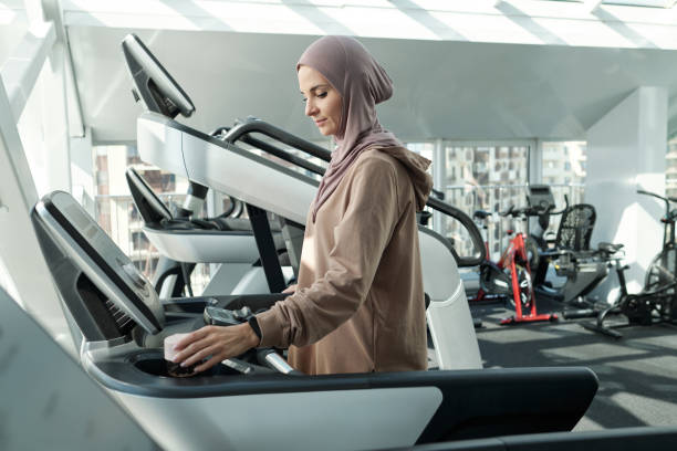 istock Woman Adjusting Settings On Treadmill 1343299887