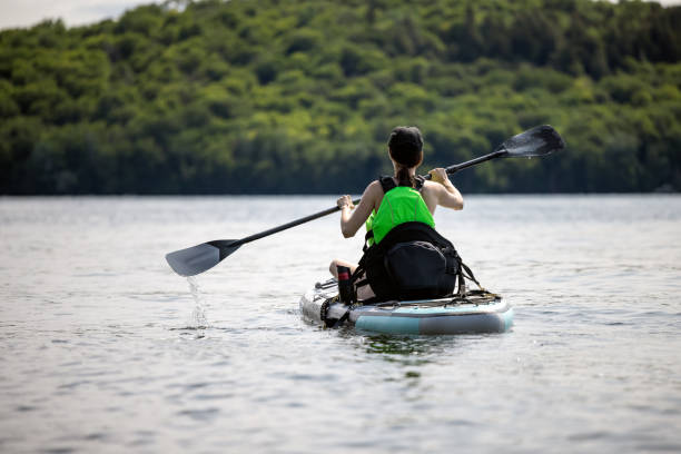 istock Woman kayaking on paddleboard on quiet lake during a warm sunny summer vacation 1343302300