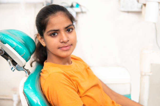 歯科治療に成功した後、笑顔でカメラを見て幸せなインドの女性。 - teenage girls pretty smile looking at camera waist up ストックフォトと画像