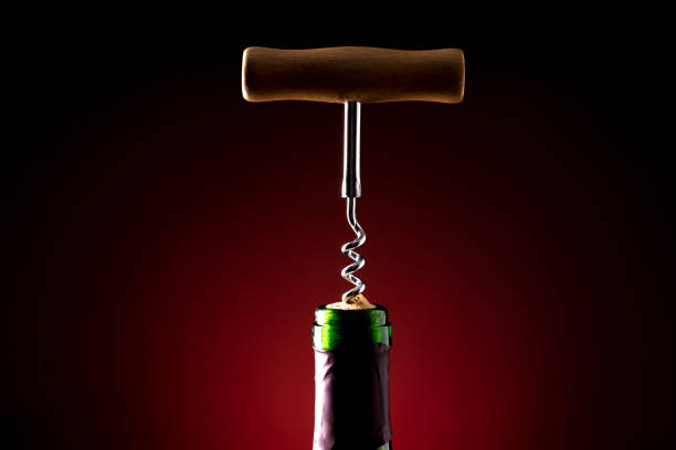 istock Wine bottle and wine opener on black background with red backlight 1343304129
