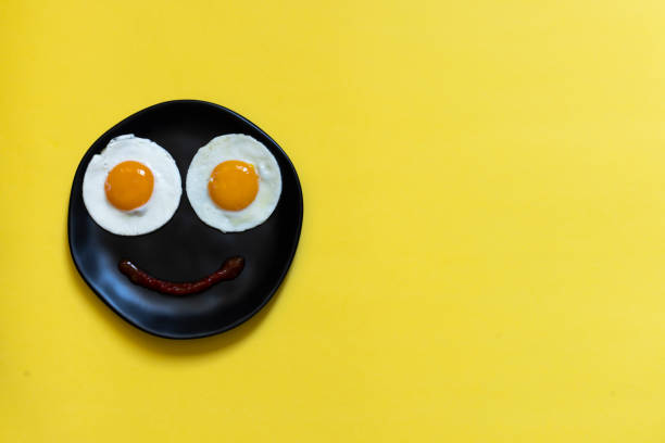 istock Two eggs in the black plate on yellow background 1343304130