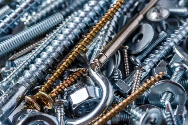 Photo of Mixed screws and nails. Industrial background. Home improvement.bolts and nuts.Close-up of various screws. Use for background, top view.