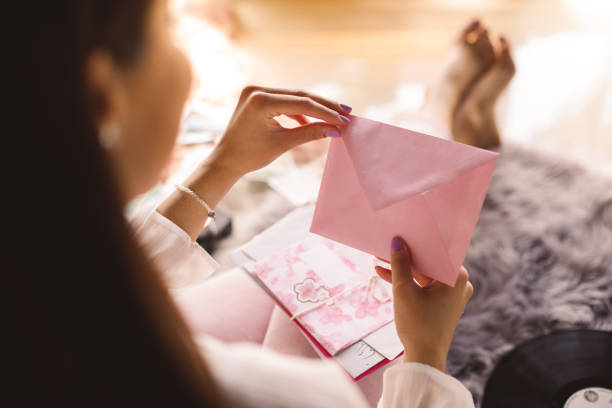 istock Young woman opening a pink envelope with a love letter 1343305249