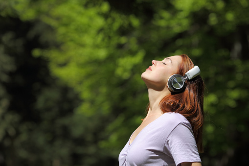 Woman relaxing meditating listening audio with headphones
