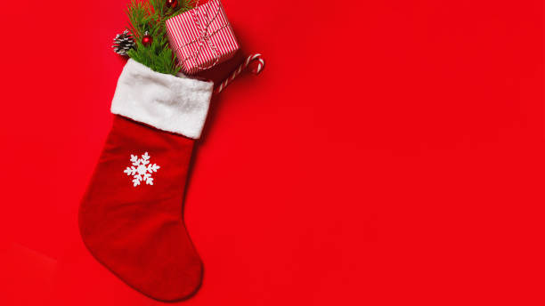 istock Christmas stocking with a gift on a red background with copy space. 1343308231