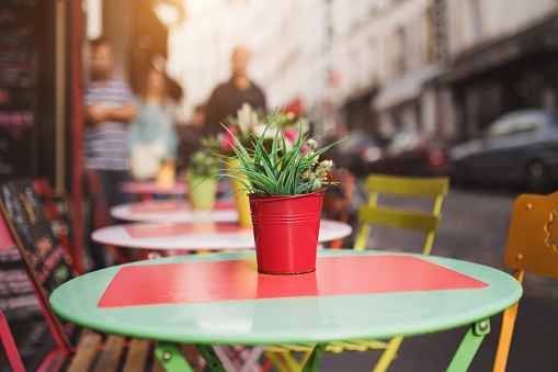 Multi-colored table of a street cafe with a perspective view of the street