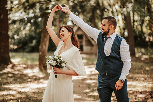 Happy young wedding couple dancing outdoors