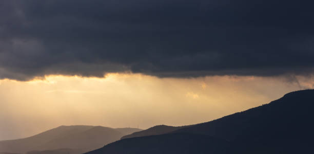 istock Heavy dark clouds on sky over mountains at sunset. Cumulus dark gray color cloudscape 1343316412