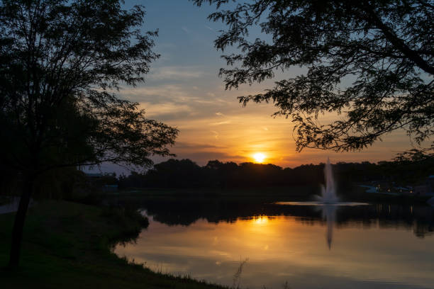 istock Sunrise over a pond with a fountain running. 1343320880