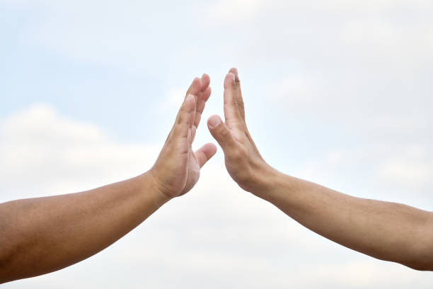 The two men clapped each other's hands, only hands。In front of the sky background