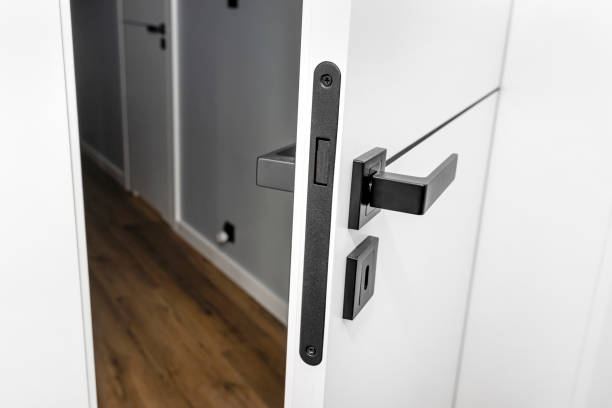 istock Modern white door with matte black handle and magnetic locks, lock with insert key. 1343336458