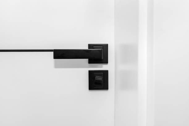 istock Modern white door with matte black handle and magnetic locks, bathroom door lock. 1343336518