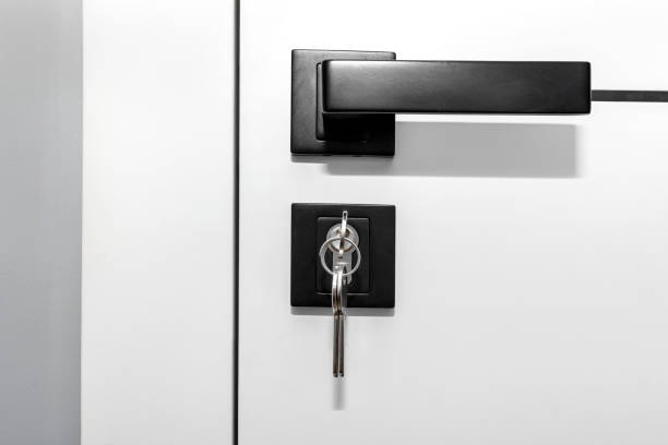 istock Modern white door with matte black handle and magnetic locks, lock with key inserted. 1343337067
