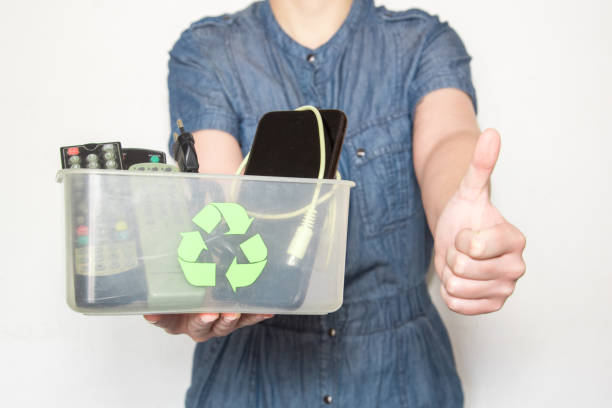 istock Woman holding a recycling box with electronics doing the ok sign 1343337600