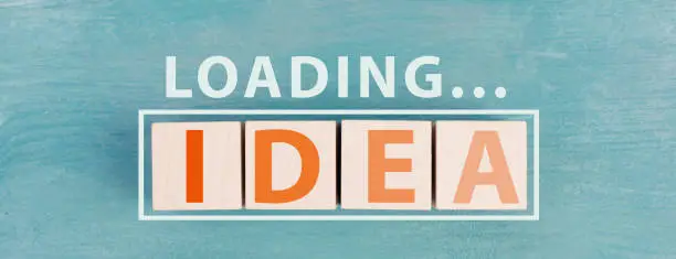 The word idea is standing on wooden cubs in orange color,blue background, loading symbol