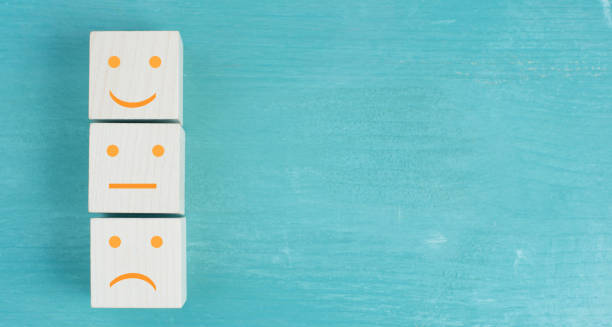 istock Three wooden cubes with smiling and sad faces on a blue bakcground, customer rating 1343338859