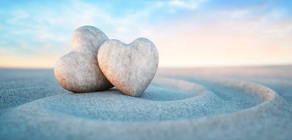 Two heart shaped pebbles on spiral sand waves with evening sun - 3d illustration