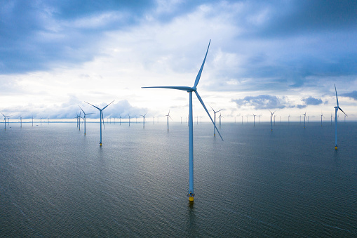 Drone photography of the Fryslân wind farm in the Frisian part of the IJsselmeer, near the dike. The offshore wind farm is completely located in the IJsselmeer. Place for text.