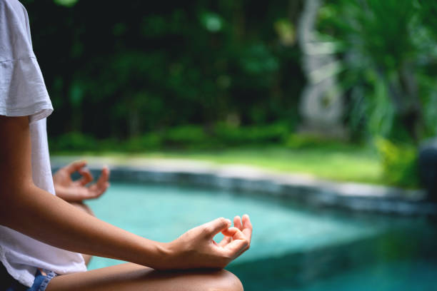 istock Woman practicing yoga by the pool 1343341097