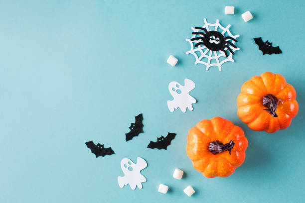 istock Halloween ornate with small pumpkins paper ghosts and spiders on turquoise 1343342648
