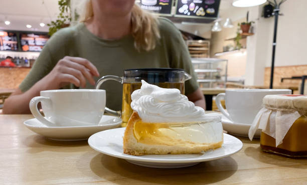 close-up de peça bolo de gelatina transparente com creme de merengue sobre a mesa em café com menina loira - five oclock tea - fotografias e filmes do acervo