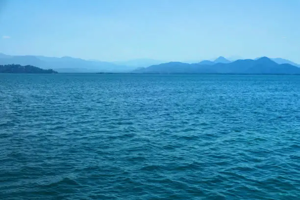 Mountain lake on a summer day - turquoise water in the sun - view of the mountains in a foggy haze