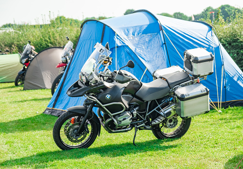 4x4 and camper van show 2021 in Stratford, Warwickshire, UK -  September 2021. BMW tourer motorcycle parked outside a blue tent on the event campsite