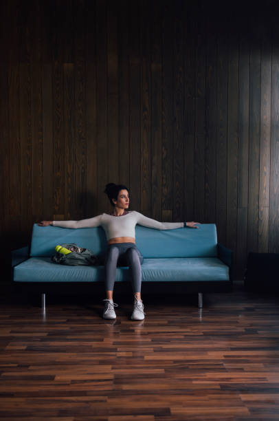 istock Young Woman Sitting on Blue Couch 1343361675