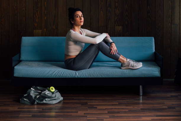 istock Young Woman Sitting on Blue Couch and Looking at Camera 1343361685