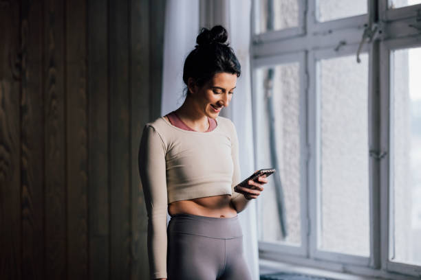 istock Smiling Woman Using Mobile Phone at Home 1343361788