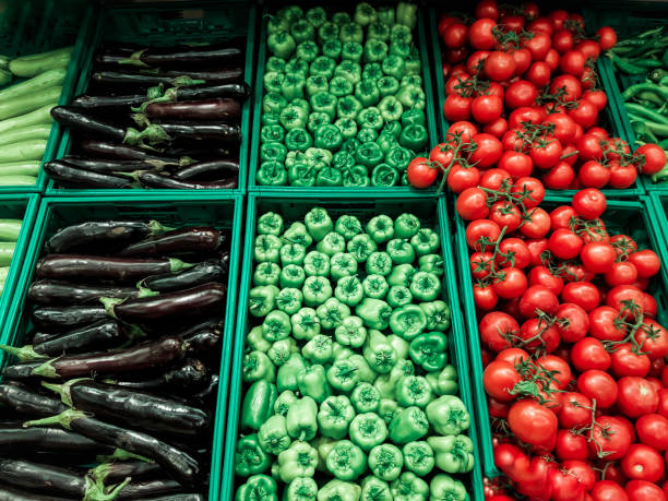 istock Eggplants, bell peppers and tomatoes lined up at supermarket stall 1343367738