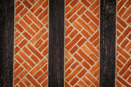 An ornate wall made of wooden beams and red patterned brick