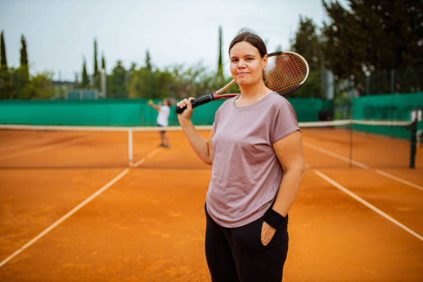 Confident and determinated young female tennis player in the making Portrait of a confident female tennis player, during her outdoor tennis practise on the clay tennis court, with her male tennis coach tennis coach stock pictures, royalty-free photos & images