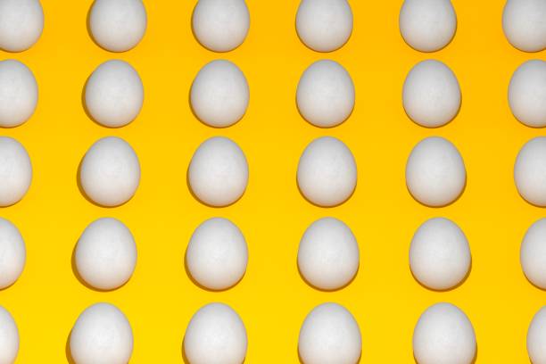 High angle view of eggs arranged on yellow background