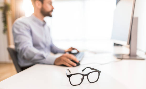 istock Eyeglasses on a busy businessman's desk. 1343372659