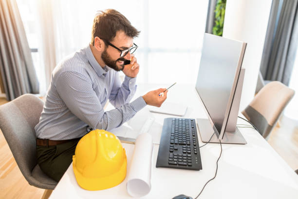 istock Happy young businessman talking on phone while working in office on desktop computer. 1343372704