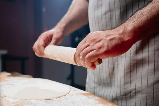 istock hands roll the dough into a thin layer. Cooking pizza, noodles or pitta at home 1343376207