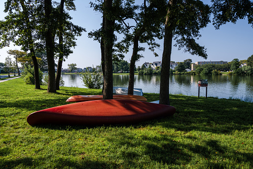 Photo of a red canoe on green grass by Spring Lake at the Jersey Shore.