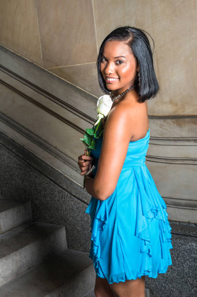 young black girl holding white rose, smiling - garment fragility women skirt imagens e fotografias de stock