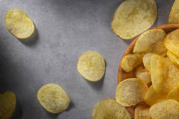 istock Potato chips in wooden bowl on a concrete background 1343382350