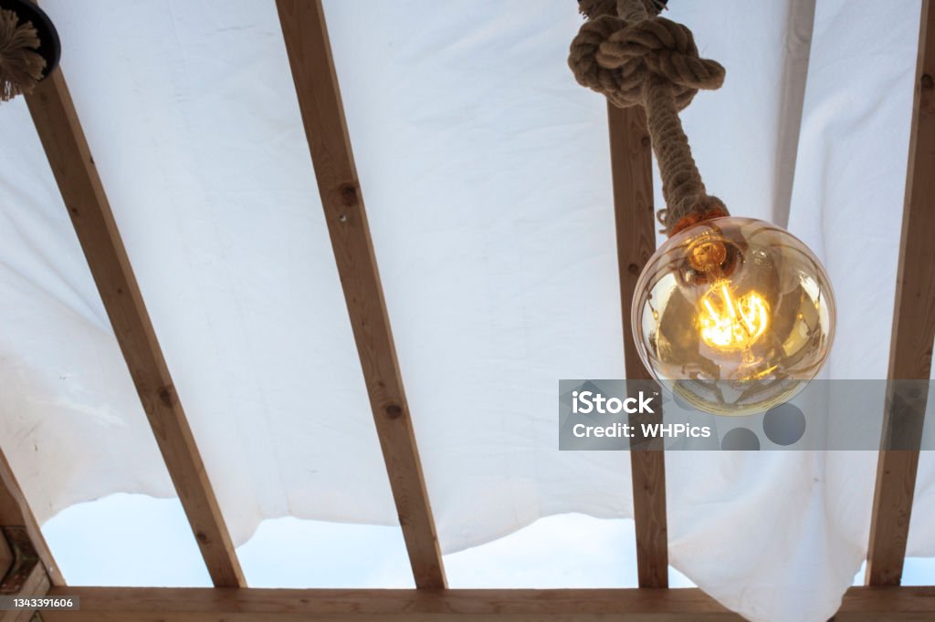 Rope light bulb over canvas pergola cover Rope light bulb over canvas pergola cover. Low angle view Backgrounds Stock Photo