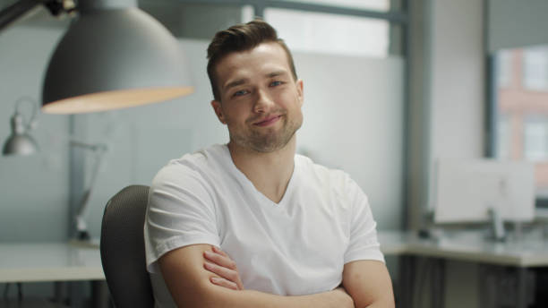 istock A positive, good-looking young man in the open office smiles while looking directly at the camera. A good startup of a successful businessman 1343394782